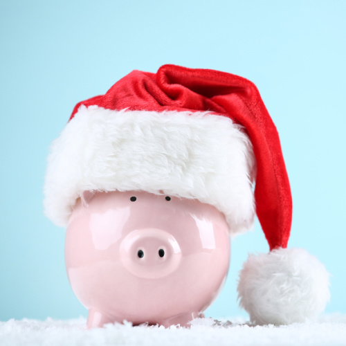 Red santa hat with piggybank on blue background